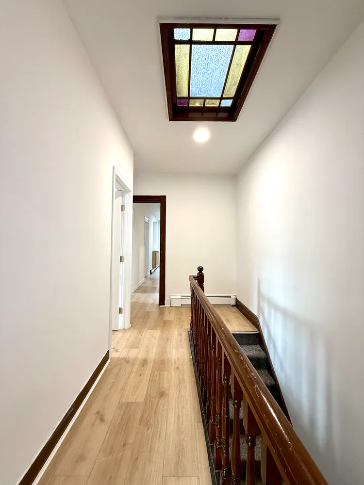 a view of a hallway with wooden floor and staircase