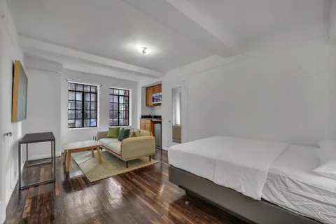 a bedroom with a bed wooden floor and lamp