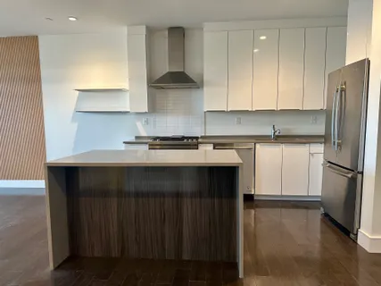 a kitchen with a sink a refrigerator and cabinets