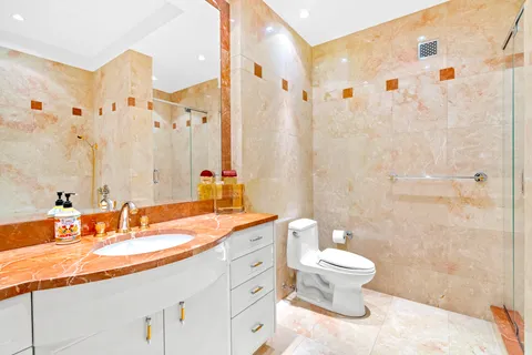 a bathroom with a double vanity sink toilet and shower