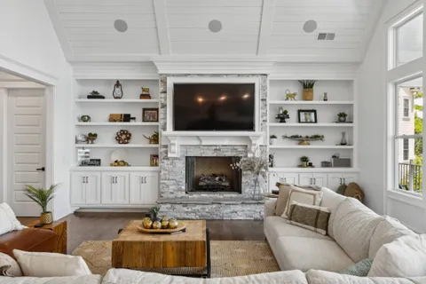 a living room with furniture a fireplace and a flat screen tv