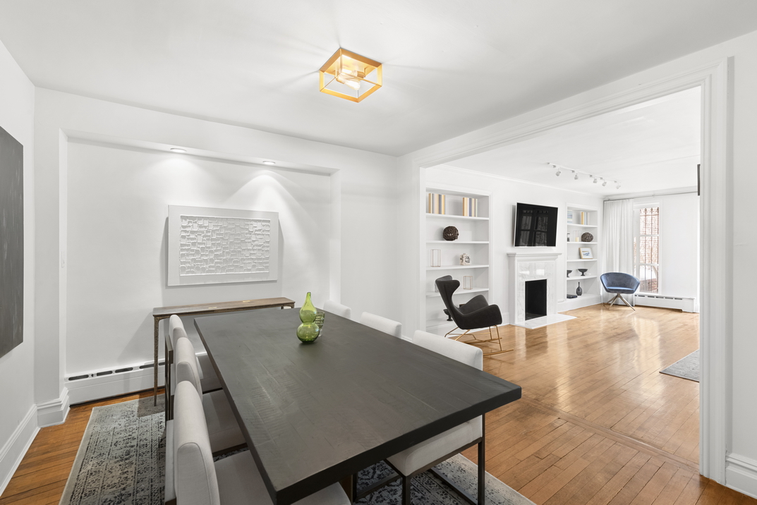 209 East 61st Street Manhattan, NY 10065 - Photo 21 of 27 a living room with dining table a rug and kitchen view