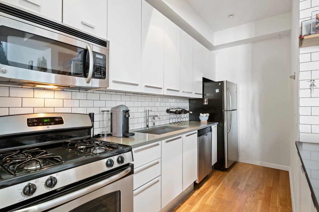 122 West Street, Unit PHA Brooklyn, NY 11222 - Photo 2 of 14 a kitchen with stainless steel appliances a stove a sink and a microwave