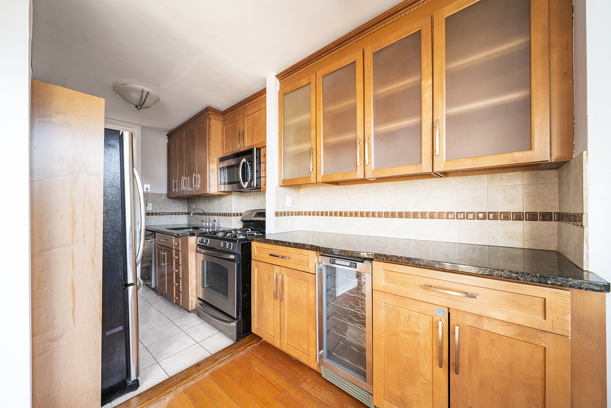 195 Willoughby Avenue, Unit 1517/1518 Brooklyn, NY 11205 - Photo 6 of 11 a kitchen with stainless steel appliances granite countertop a stove and a refrigerator