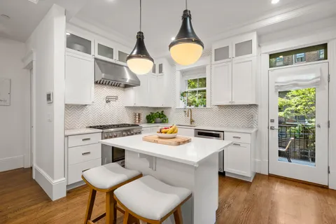 a kitchen with a stove cabinets and wooden floor