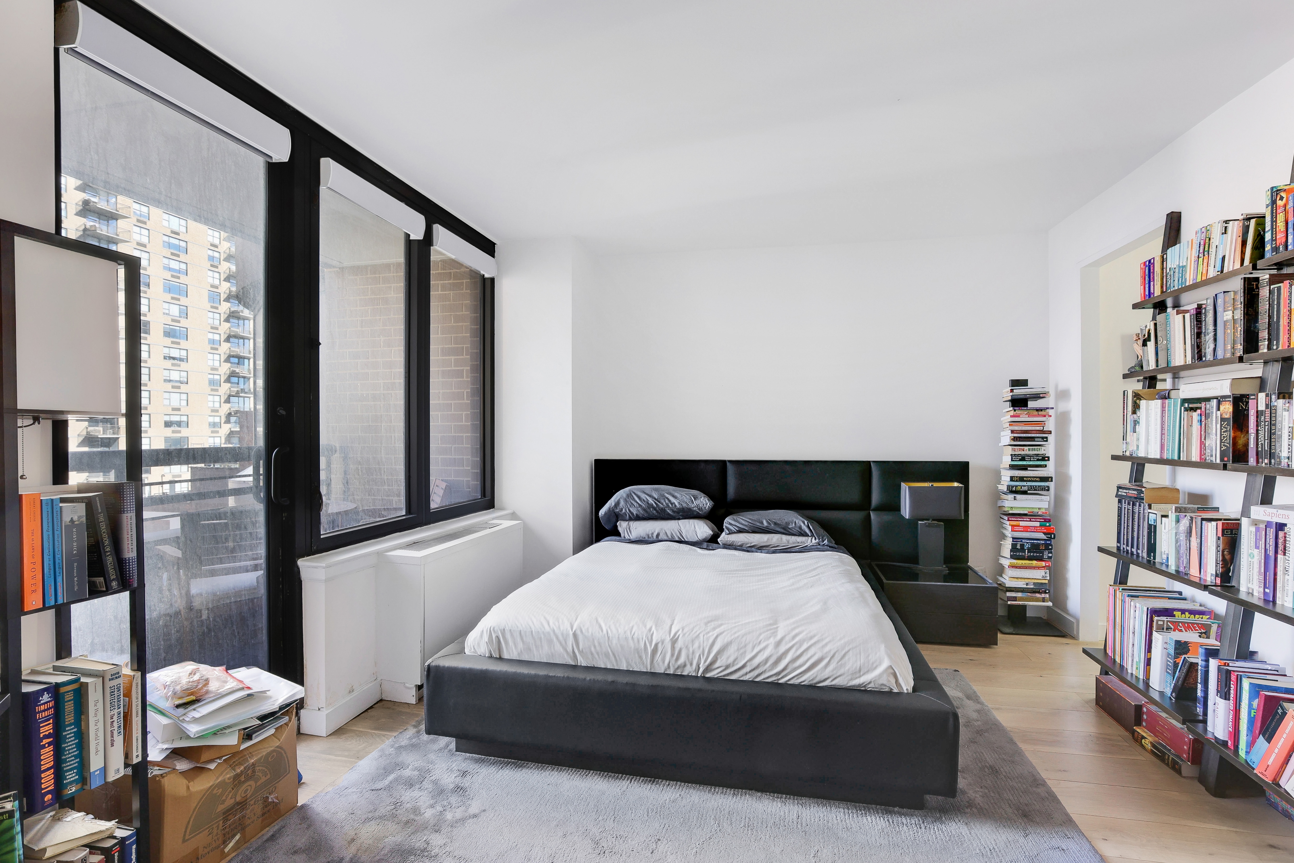330 East 38th Street, Unit 20E Manhattan, NY 10016 - Photo 5 of 17 a living room with a couch and a book shelf