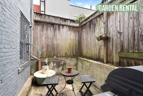 a view of a chairs and table in the back of a building