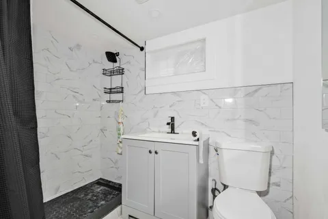 a bathroom with a sink a toilet and shower