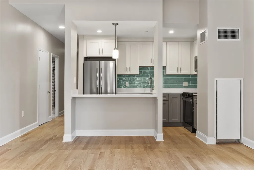 a view of kitchen with stainless steel appliances refrigerator oven and cabinets