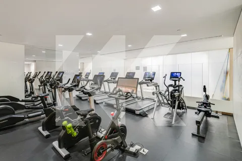 a room with gym equipment and large mirror