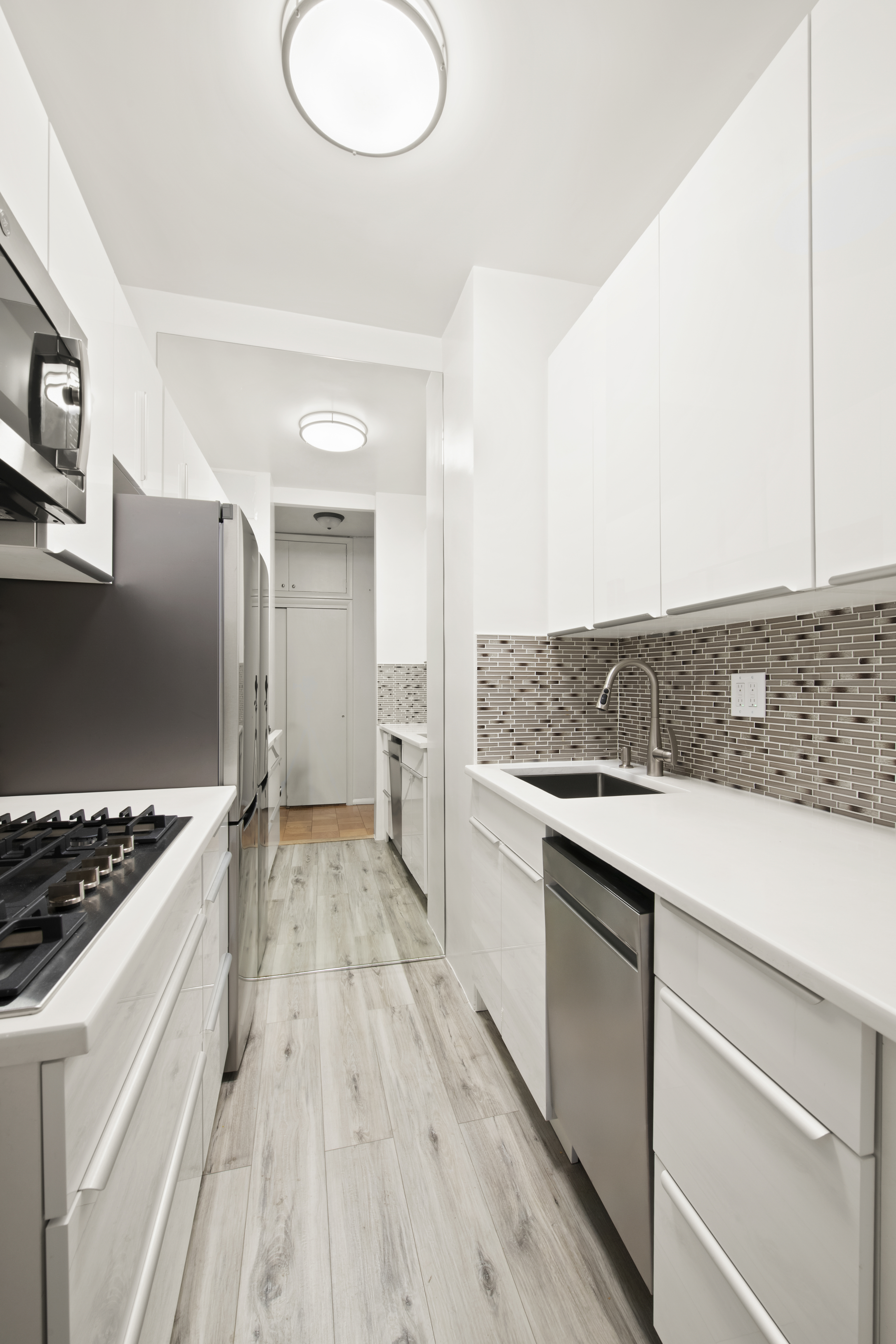 58 West 58th Street, Unit 10D Manhattan, NY 10019 - Photo 3 of 10 a kitchen with a sink stove and cabinets