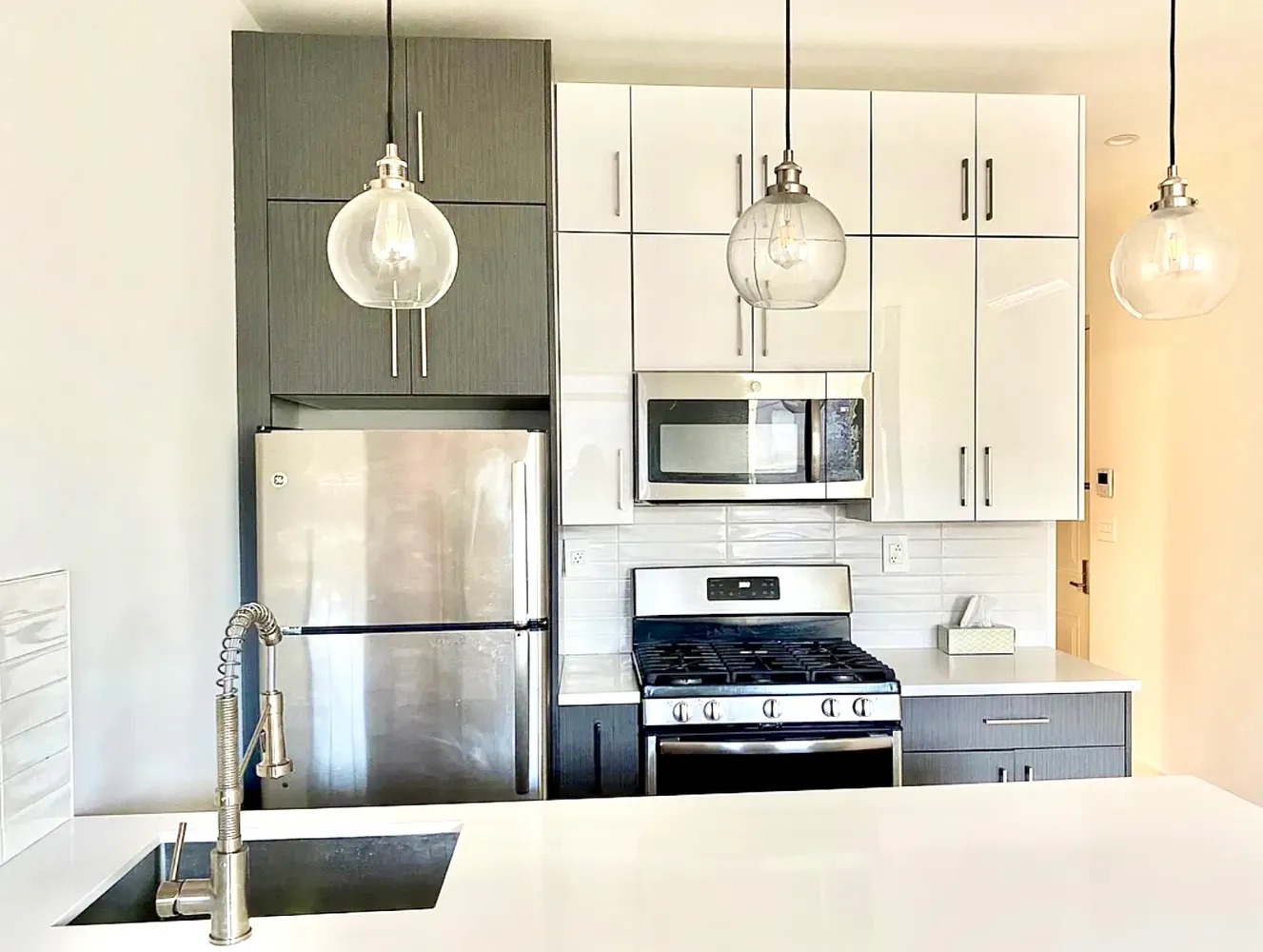 a kitchen with stainless steel appliances granite countertop a sink a stove a refrigerator a microwave oven with cabinets and wooden floor