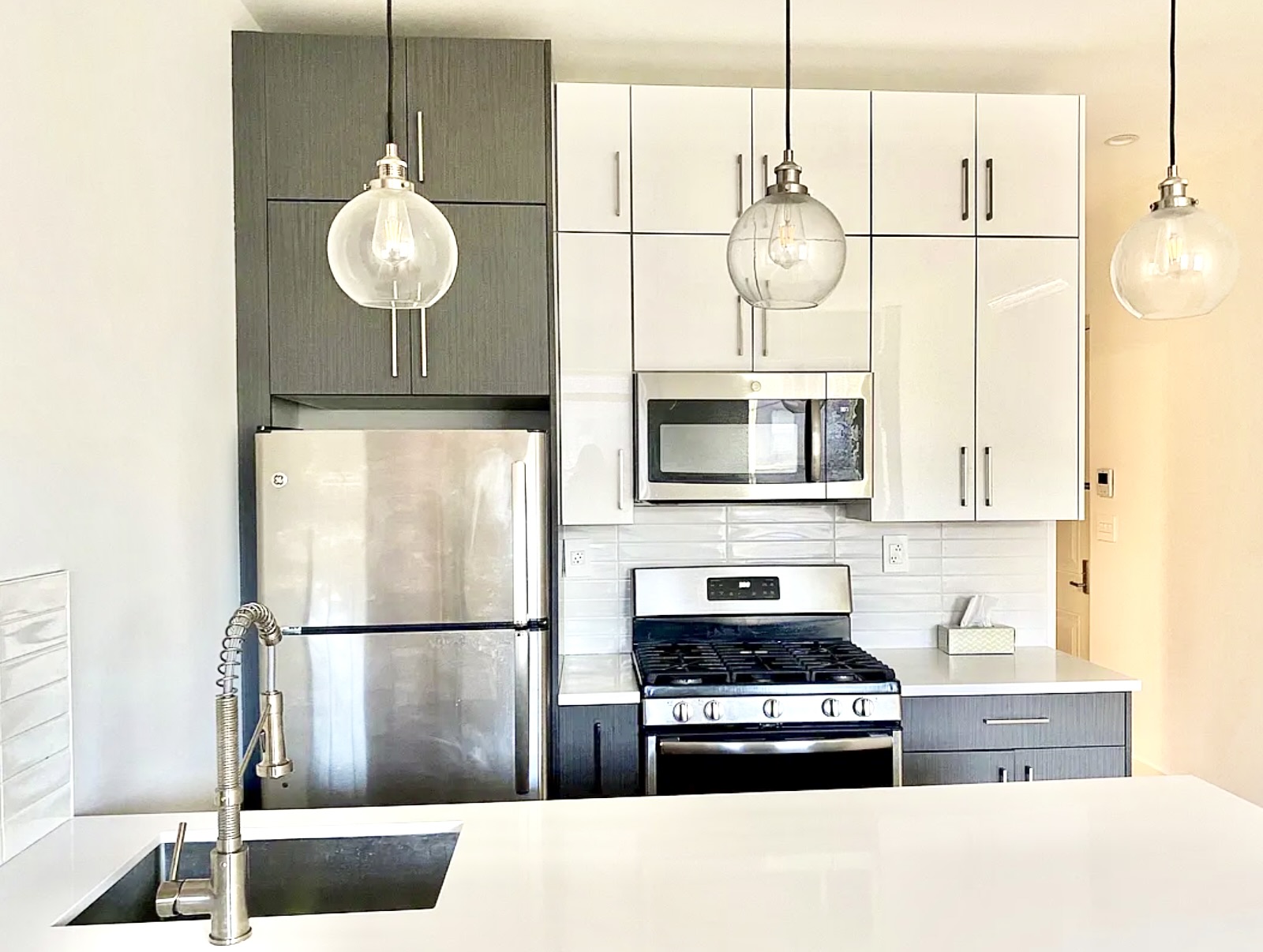 211 8th Avenue, Unit 1C Brooklyn, NY 11215 - Photo 4 of 11 a kitchen with stainless steel appliances granite countertop a sink a stove a refrigerator a microwave oven with cabinets and wooden floor