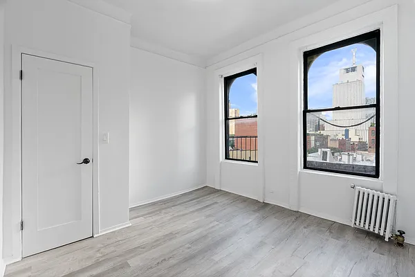 824 9th Avenue, Unit 5RN Manhattan, NY 10019 - Photo 6 of 11 an empty room with windows and closet