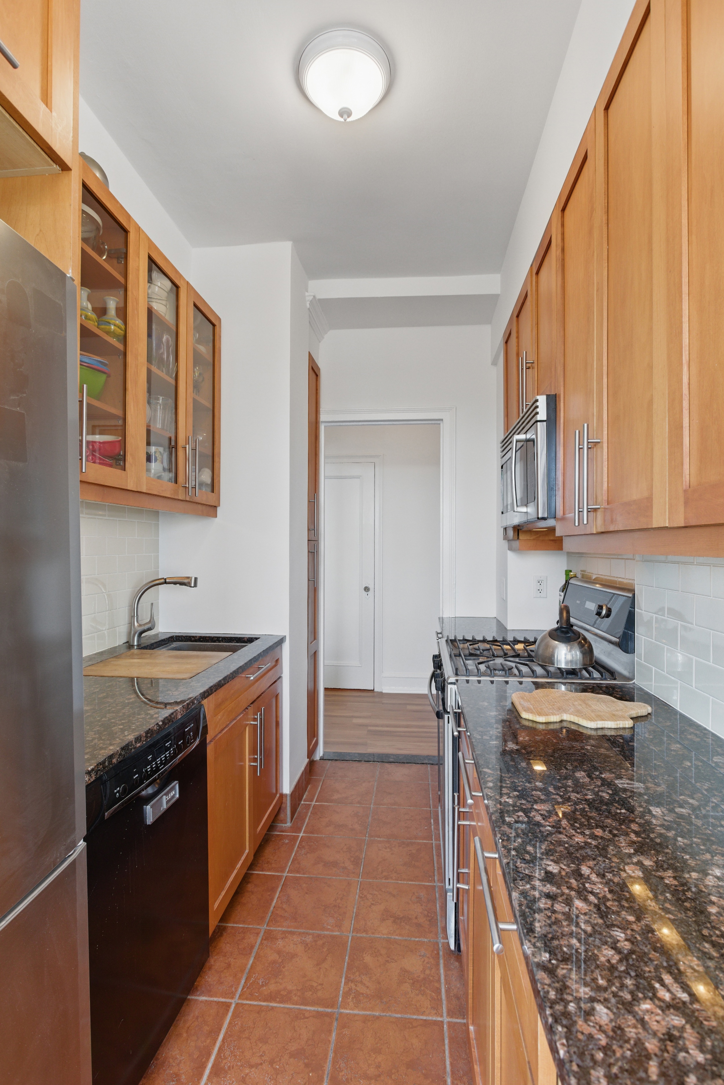 1 Plaza Street West, Unit 12C Brooklyn, NY 11217 - Photo 5 of 13 a kitchen with stainless steel appliances granite countertop a stove a sink and a microwave