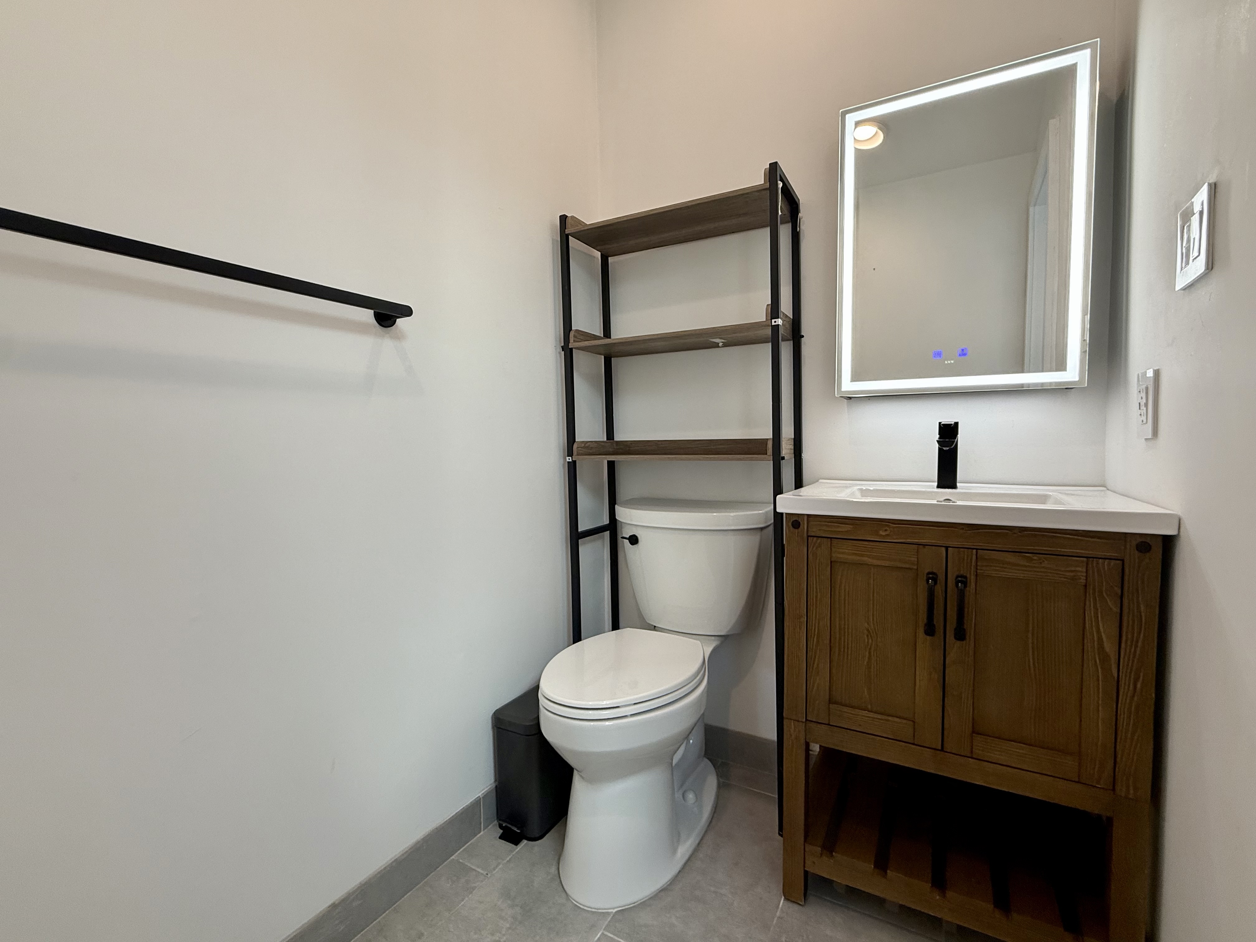 106 Battery Avenue, Unit 301 Brooklyn, NY 11209 - Photo 7 of 8 a bathroom with a toilet sink and mirror