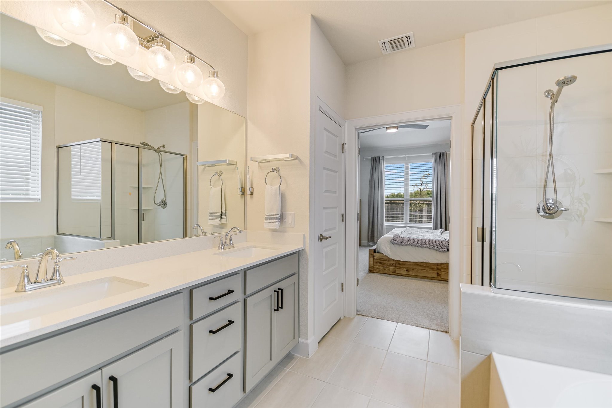 8607 McKamy Drive Austin, TX 78744 - Photo 10 of 28 a spacious bathroom with a shower sink and mirror