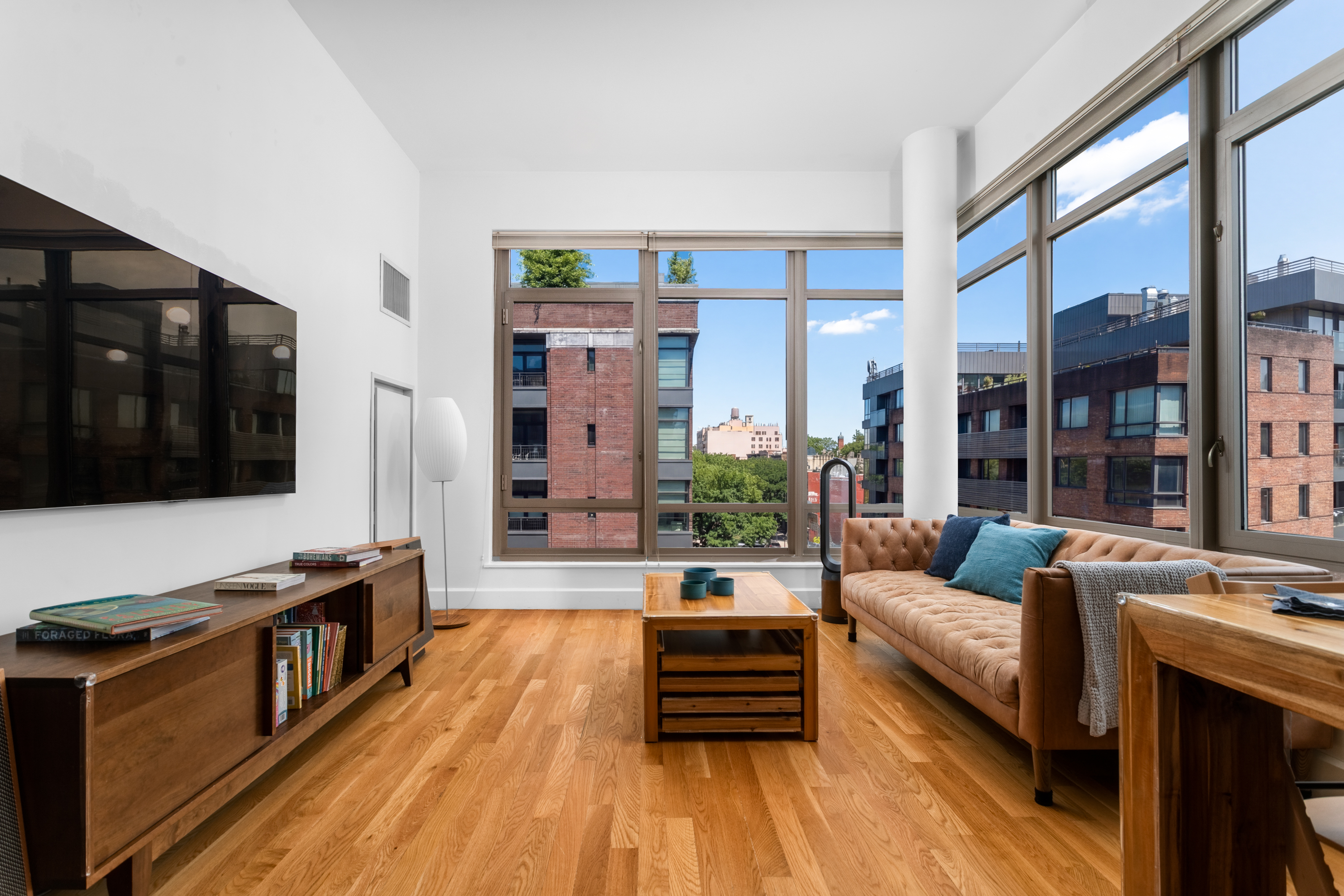 315 Gates Avenue, Unit 4E Brooklyn, NY 11216 - Photo 2 of 17 a living room with furniture and a flat screen tv