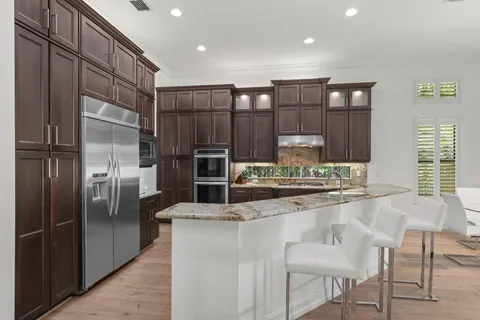 a kitchen with kitchen island a counter top space cabinets and stainless steel appliances