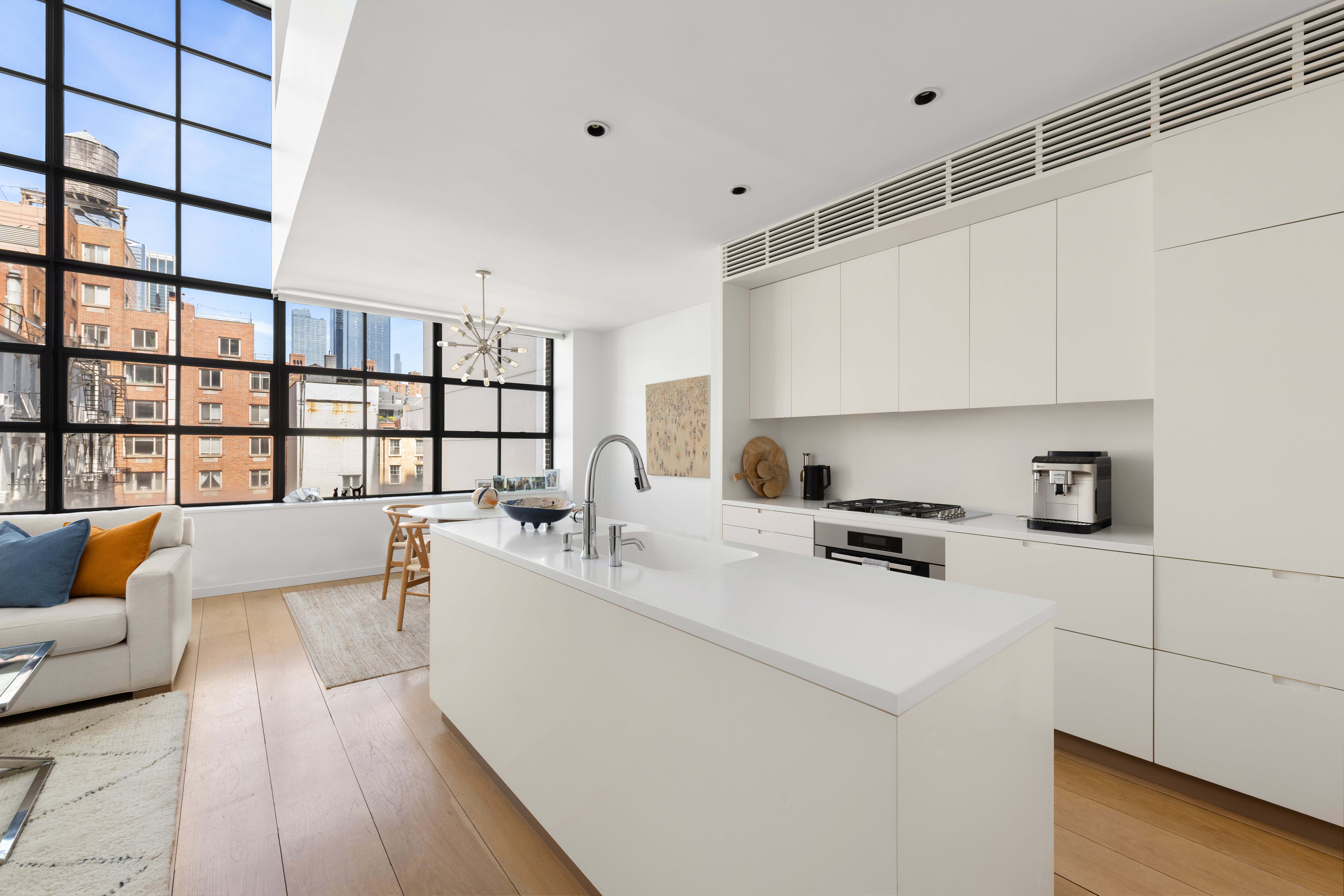 456 West 19th Street, Unit 4/5A Manhattan, NY 10011 - Photo 9 of 15 a large white kitchen with stainless steel appliances a sink a stove a chimney a refrigerator and cabinets