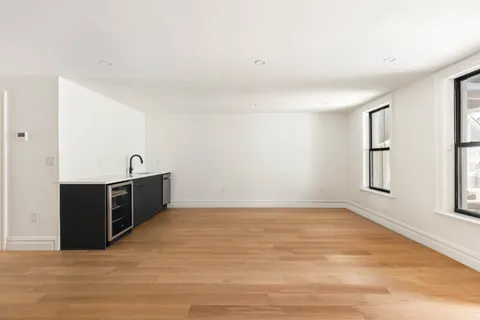 a view of a kitchen with wooden floor and electronic appliances