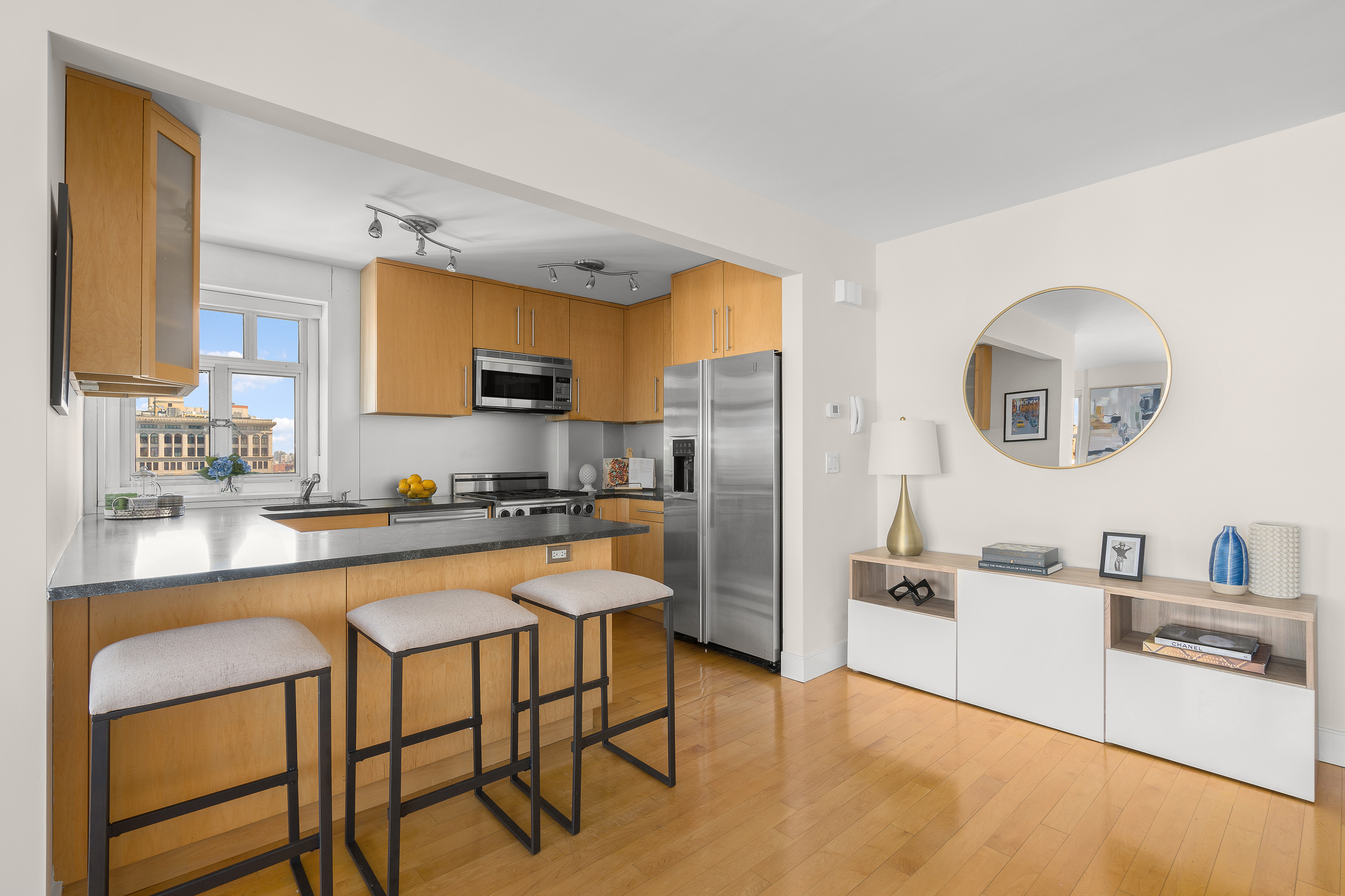 20 East 9th Street, Unit 22C Manhattan, NY 10003 - Photo 4 of 21 a kitchen with stainless steel appliances granite countertop a sink a stove a refrigerator cabinets and chairs