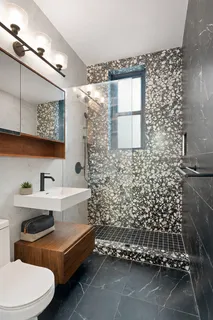 a bathroom with a sink a toilet and shower