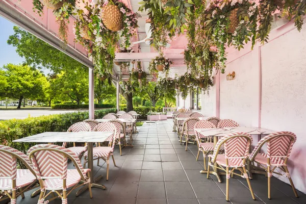 a view of a patio with a dining table and chairs with a fire pit and a large tree