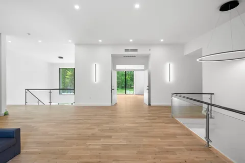 a view of an empty room with wooden floor and windows