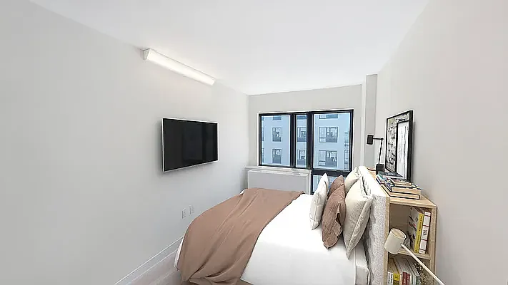 605 Hart Street, Unit 6E Brooklyn, NY 11221 - Photo 3 of 10 a bedroom with a bed and flat screen tv
