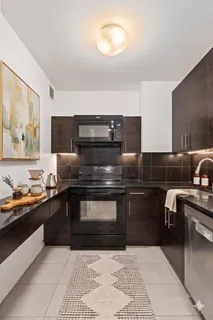 a kitchen with stainless steel appliances granite countertop a stove a sink and a microwave
