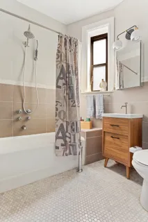 a bathroom with a tub sink and mirror