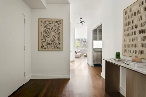 a view of a kitchen with a fridge and wooden floor