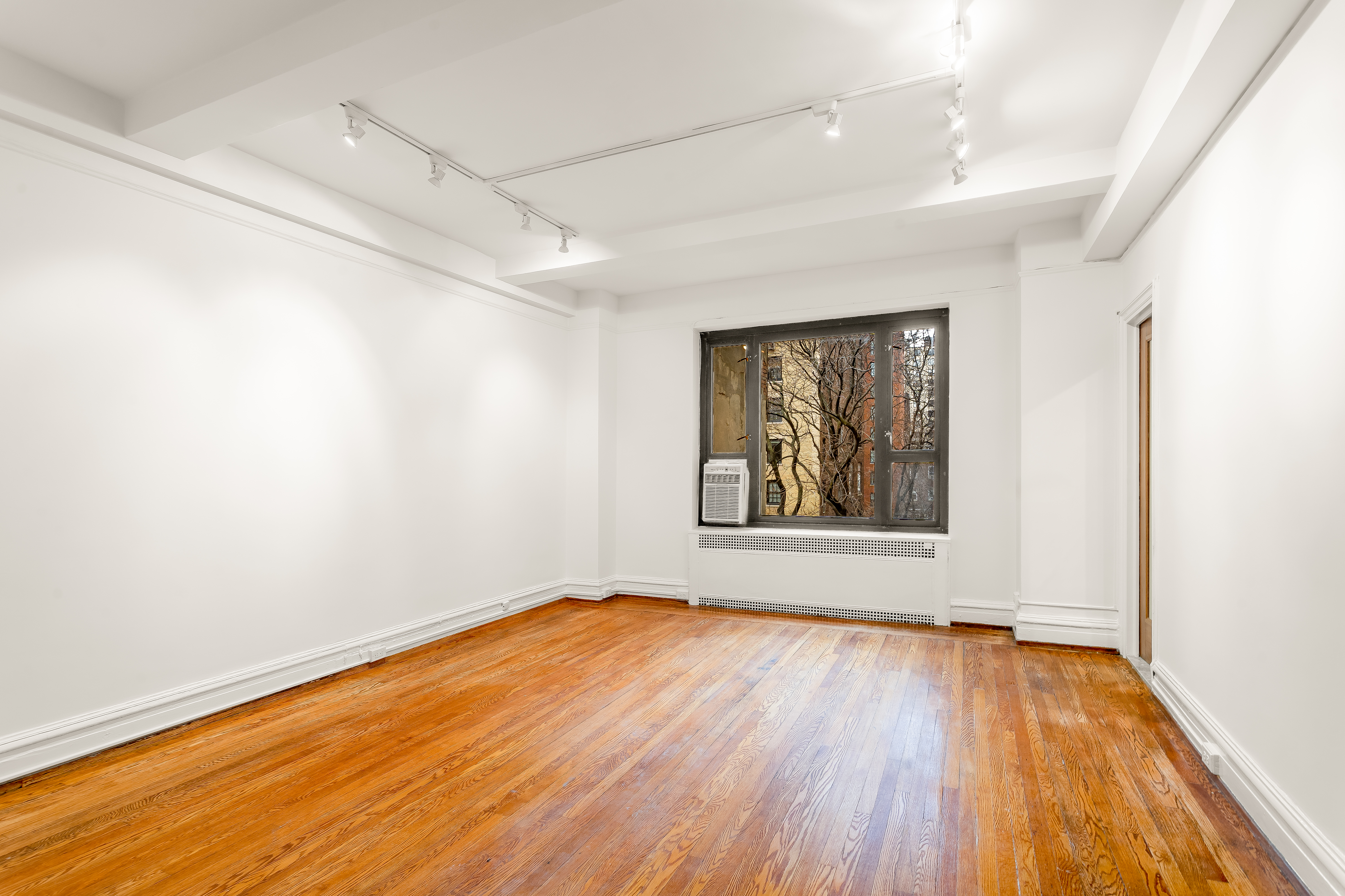 180 East 79th Street, Unit 5A Manhattan, NY 10075 - Photo 8 of 19 a view of a big room with wooden floor and windows
