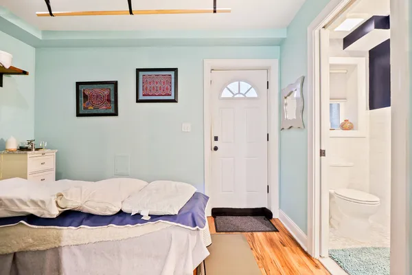 a bedroom with a bed and wooden floor