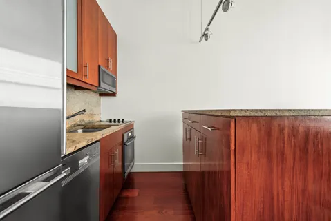a kitchen with granite countertop a sink cabinets and stainless steel appliances