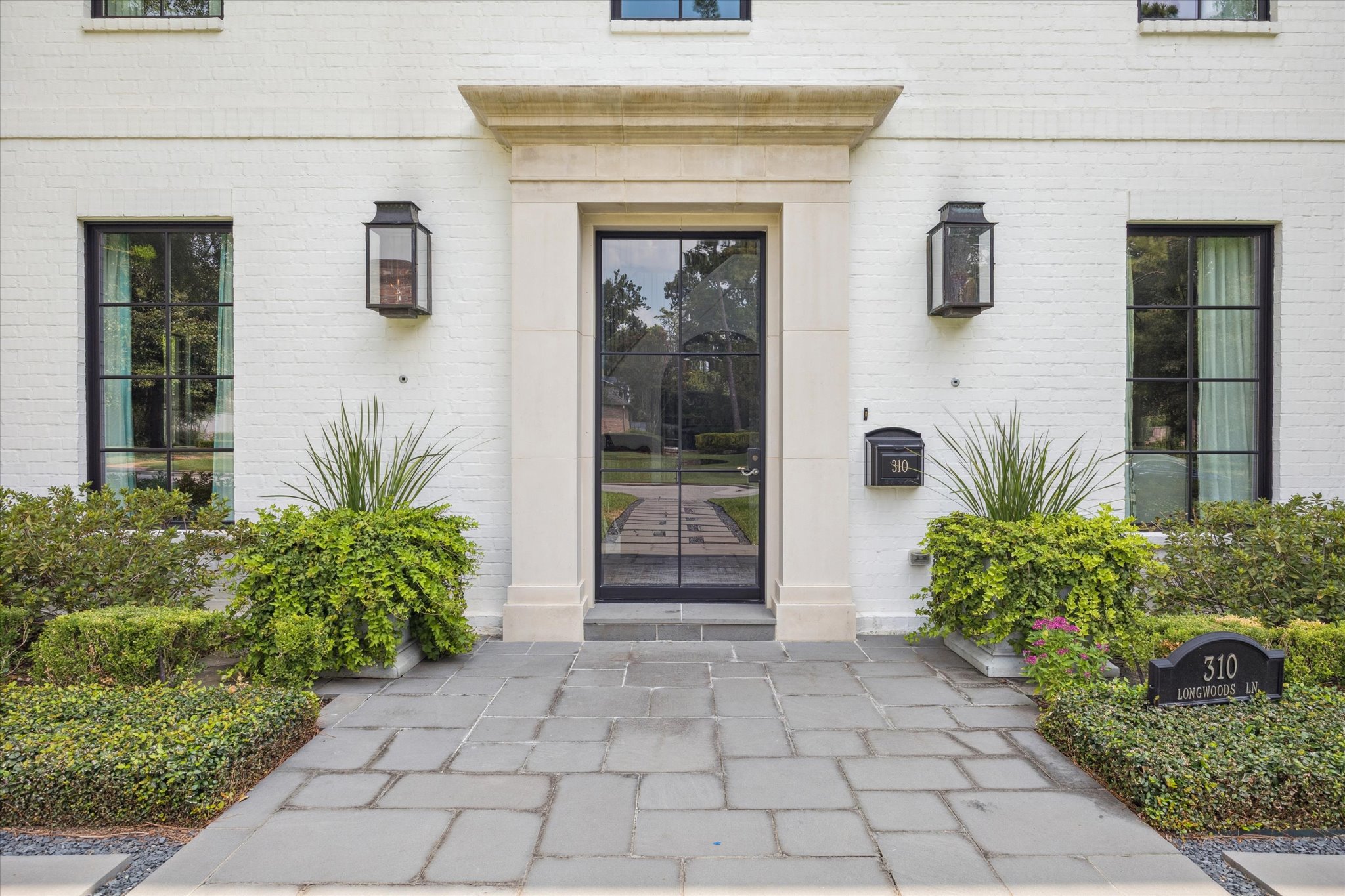 310 Longwoods Lane Houston, TX 77024 - Photo 2 of 49 a front view of a house with garden