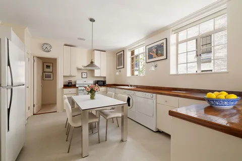 a kitchen with stainless steel appliances a dining table chairs and a refrigerator