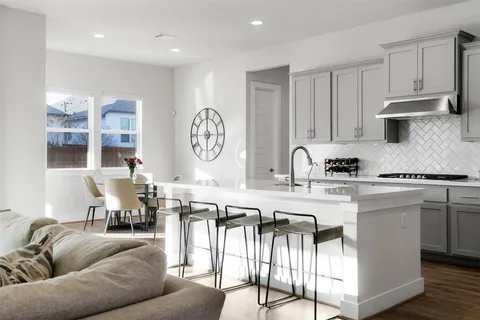 a living room with stainless steel appliances granite countertop furniture a couch and a view of kitchen