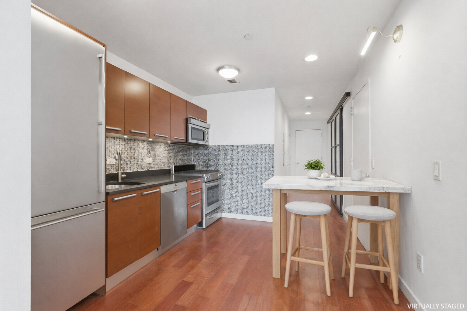 1485 5th Avenue, Unit 12G Manhattan, NY 10035 - Photo 6 of 14 a kitchen with stainless steel appliances granite countertop a white cabinets and wooden floor