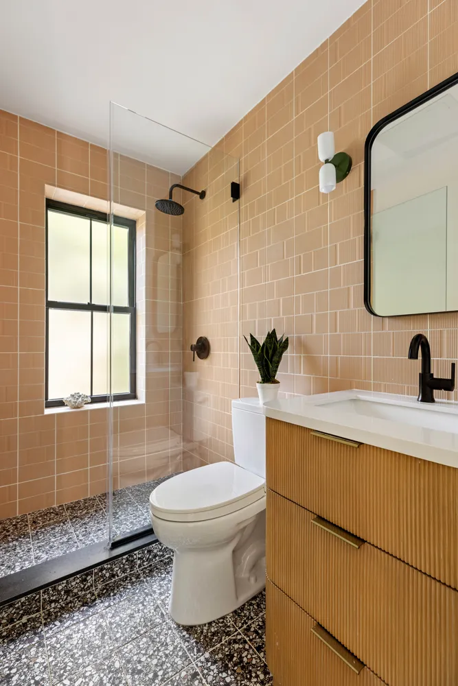 a bathroom with a sink a toilet and shower