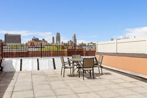 a view of a terrace with chairs and iron fence