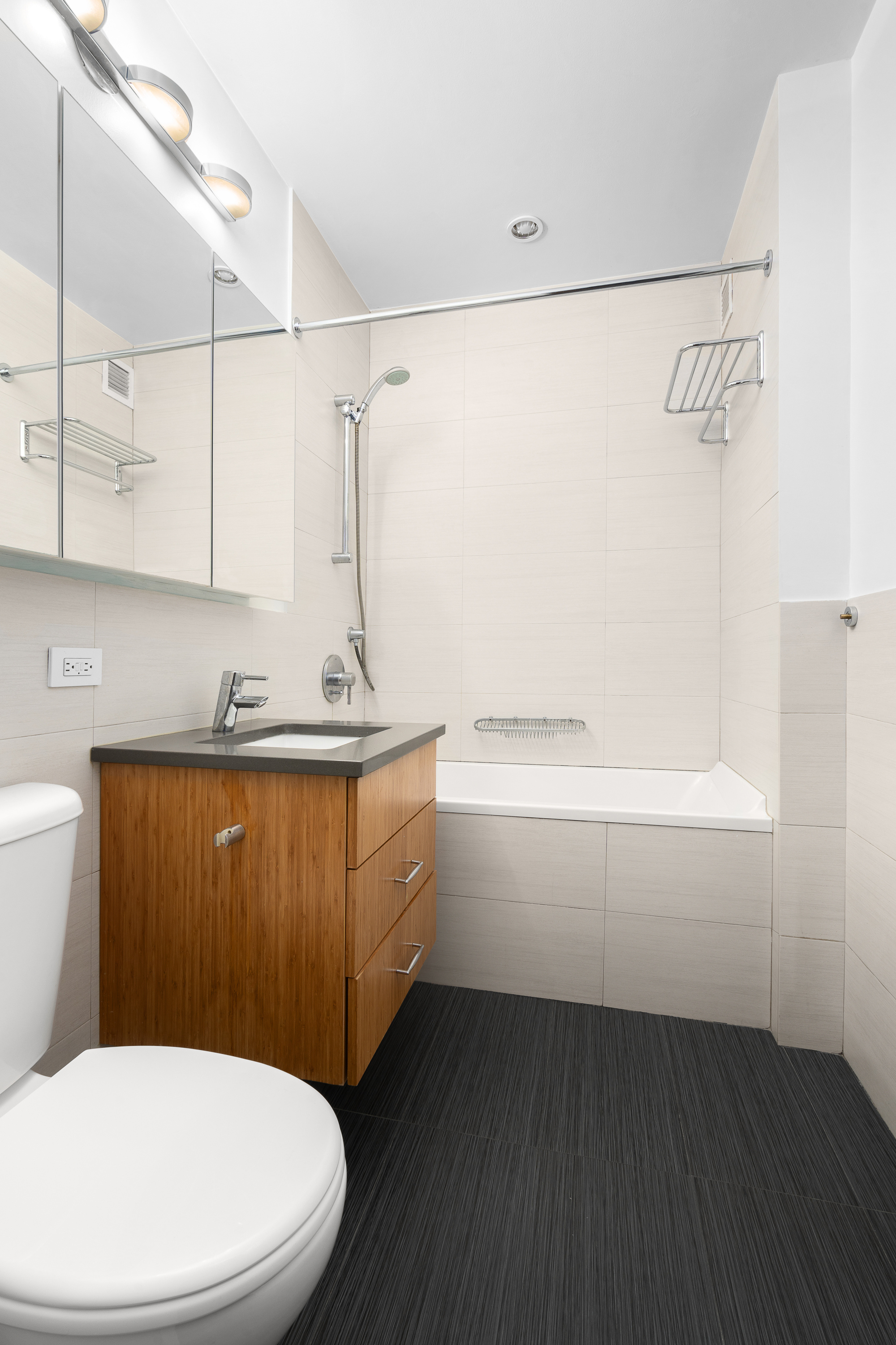 99 John Street, Unit 922 Manhattan, NY 10038 - Photo 6 of 14 a bathroom with a sink a toilet and shower
