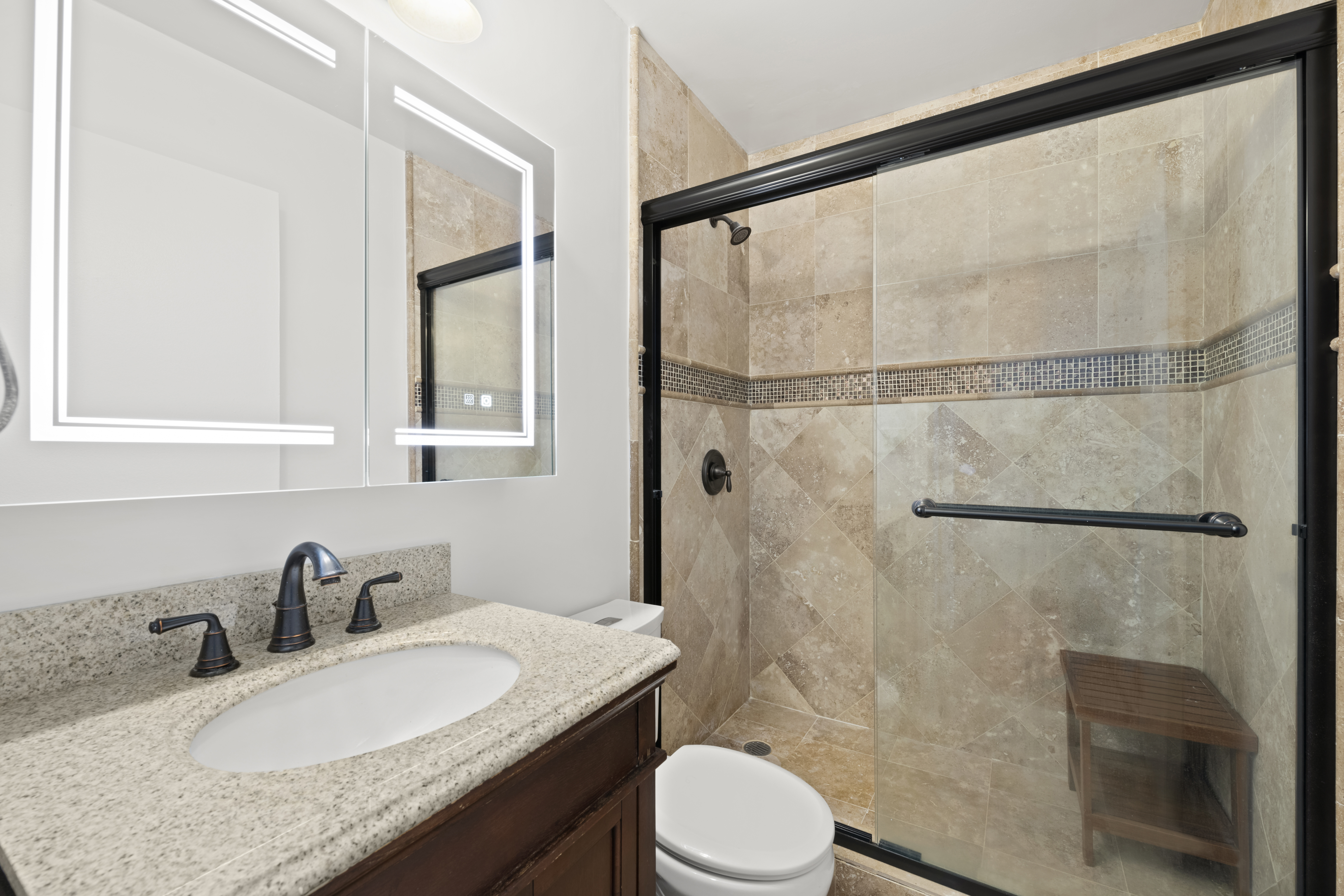 2025 Broadway, Unit 15C Manhattan, NY 10023 - Photo 6 of 12 a bathroom with a granite countertop sink toilet and shower