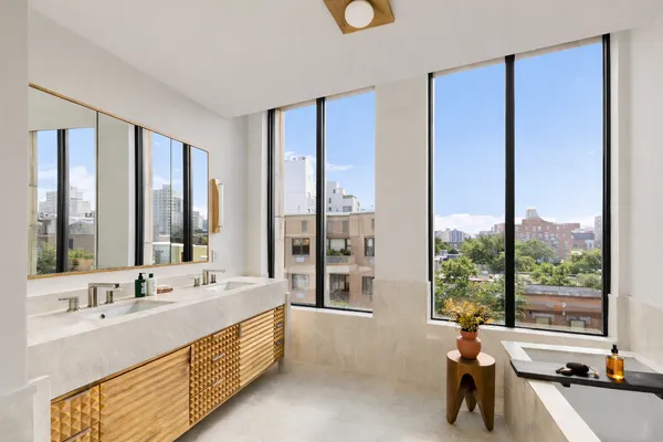 a bathroom with a double vanity sink a large mirror and a large window
