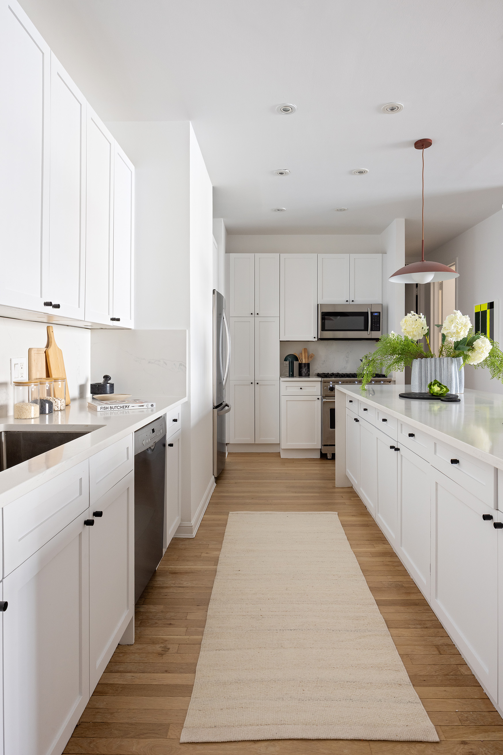 252 7th Avenue, Unit 9R Manhattan, NY 10001 - Photo 12 of 23 a kitchen with kitchen island granite countertop a sink a counter top space stainless steel appliances and cabinets