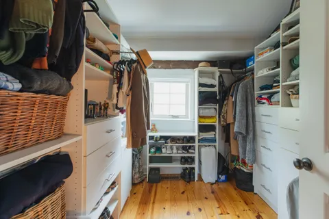 a view of walk in closet with clothes and shoes