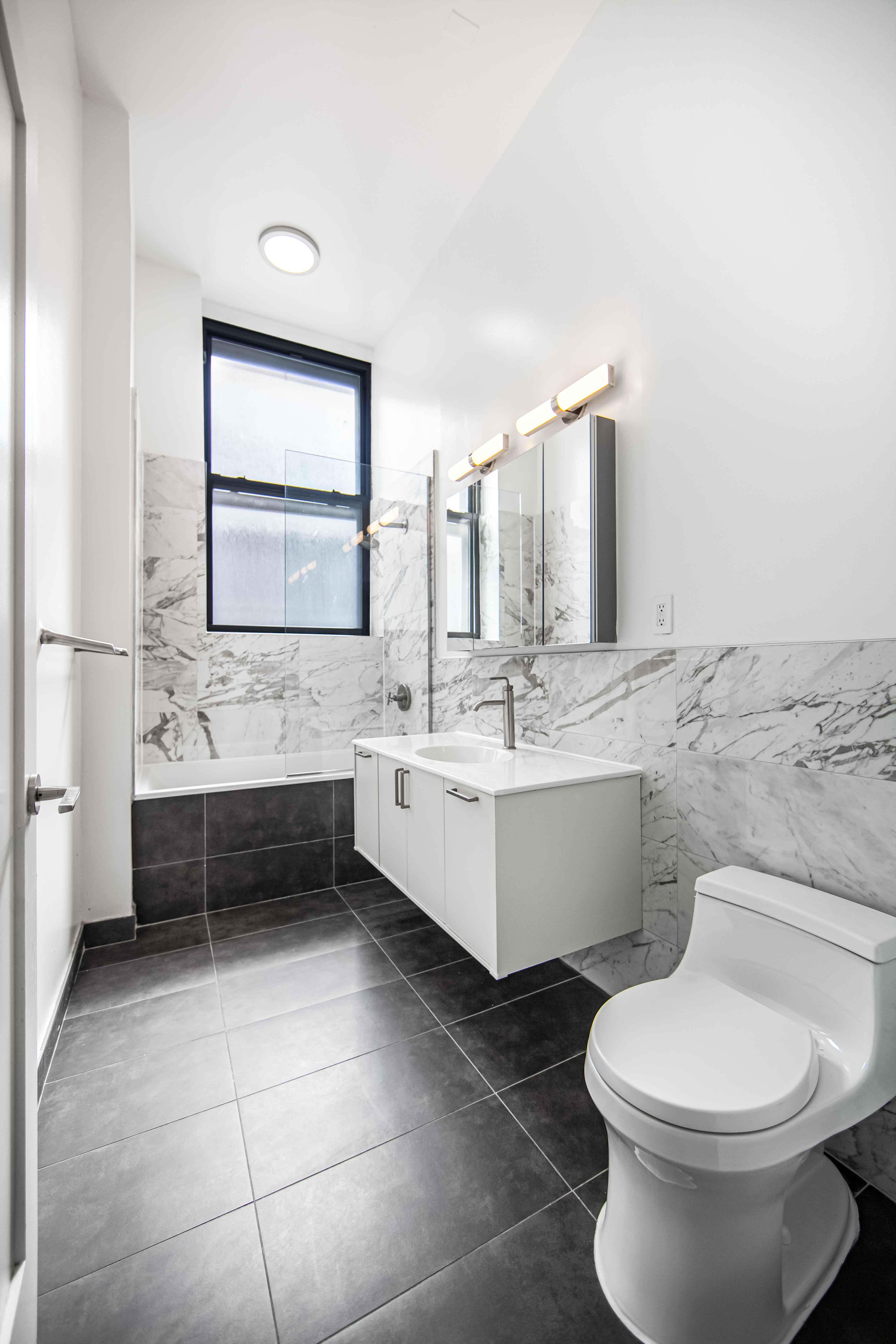 44 Berry Street, Unit 2K Brooklyn, NY 11249 - Photo 6 of 6 a bathroom with a sink mirror vanity and toilet