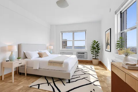 a bedroom with a bed and a potted plant