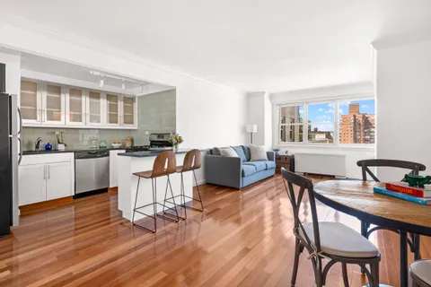 a living room with furniture and a dining table with wooden floor